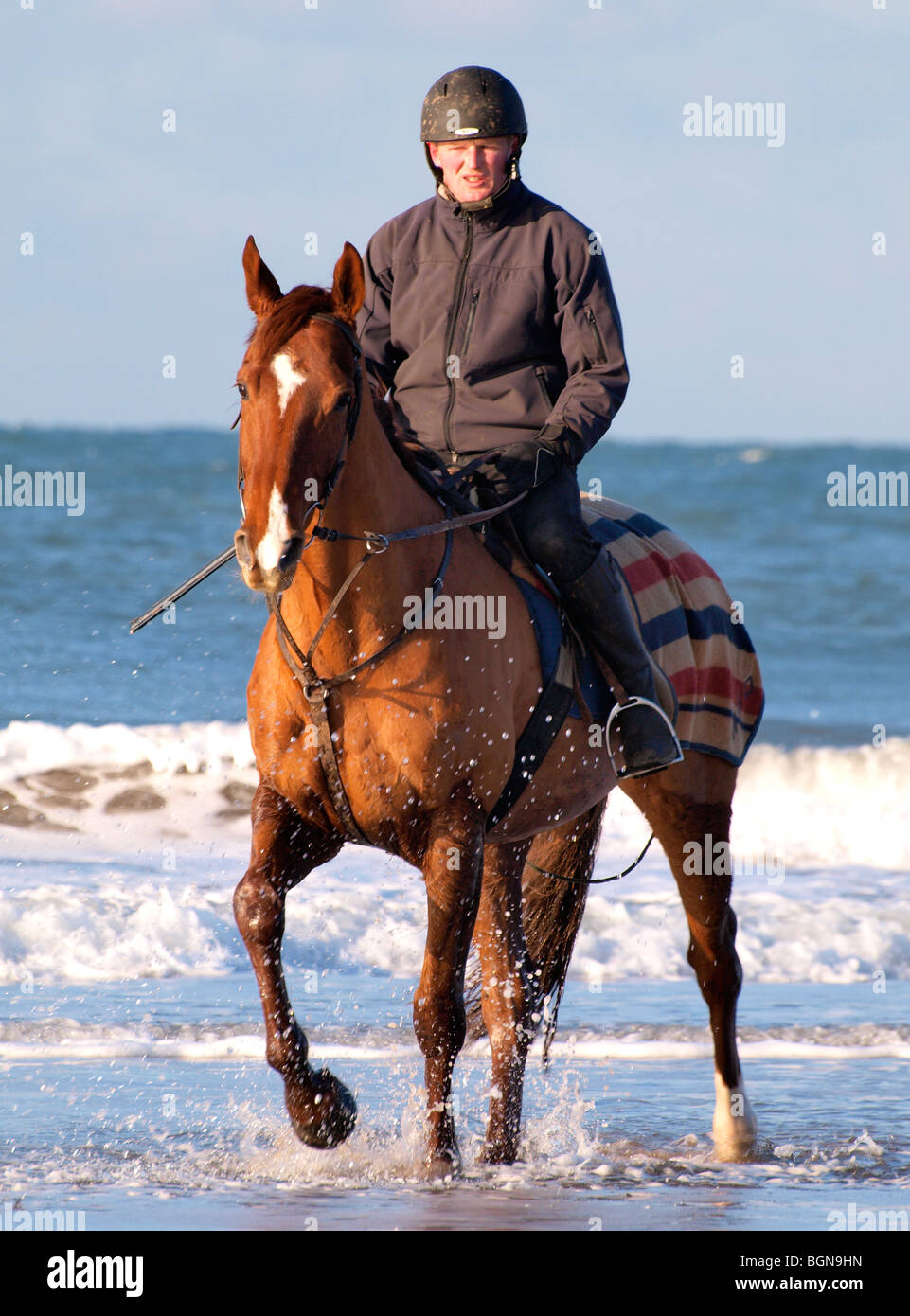 Horse and jockey on the beach, Bude, North Cornwall. Stock Photo