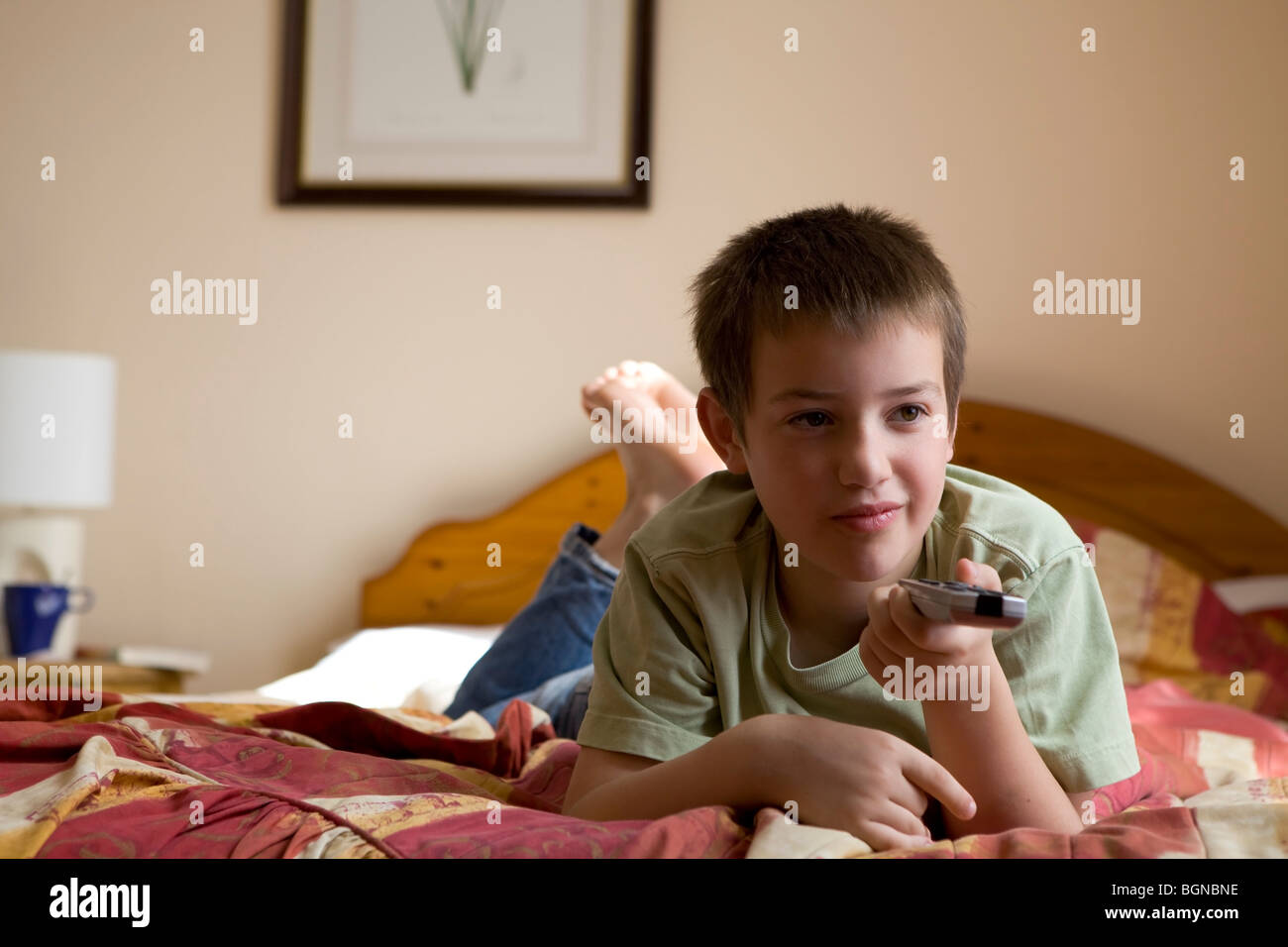 little cute boy watching TV lying on bed Stock Photo - Alamy
