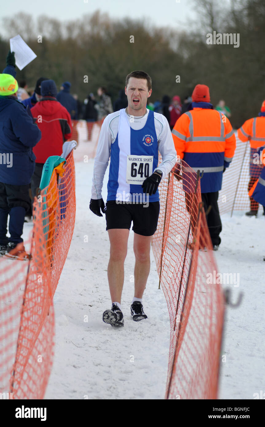 Runner in finishing funnel at end of cross-country race in snow Stock Photo