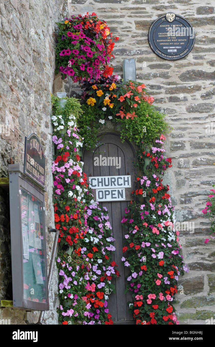 Church door decorated with summery flowers Stock Photo