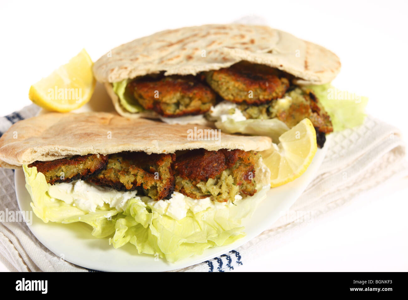 A falafel and pitta bread sandwich with lettuce, thick yoghurt and