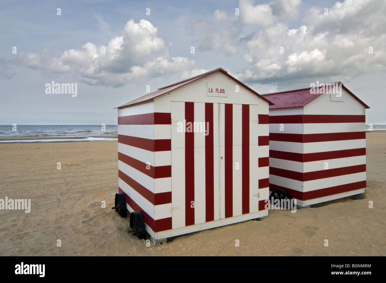Row Of Colourful Red White Striped Beach Cabins On Wheels Along