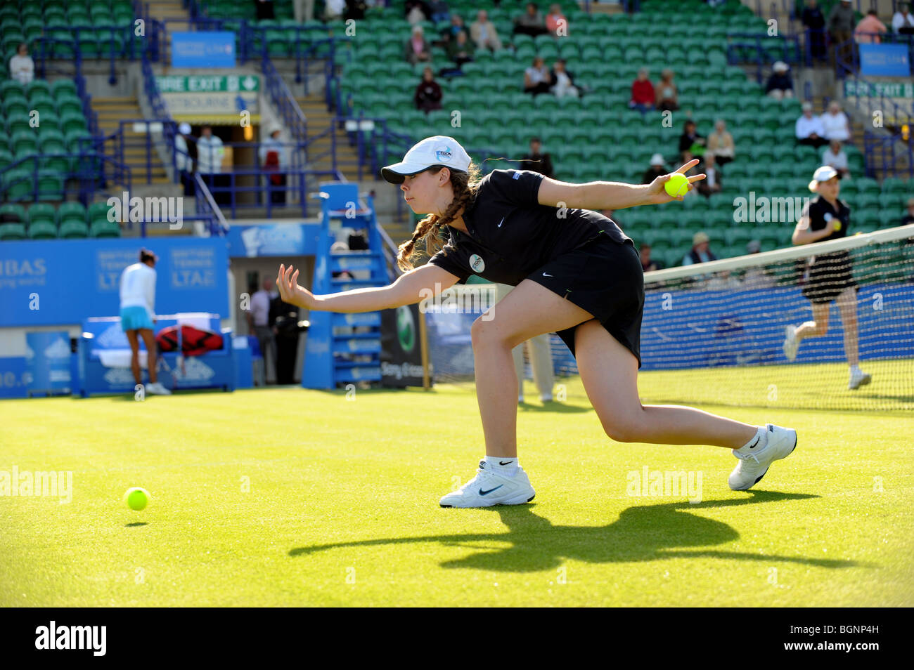 A ball girls throws balls up the court ready for the next match at the Aegon International 2009