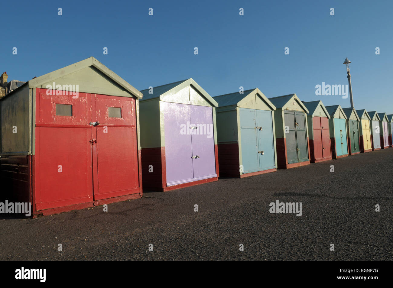 Colourful painted beach huts on the seafront at Brighton and Hove. Stock Photo