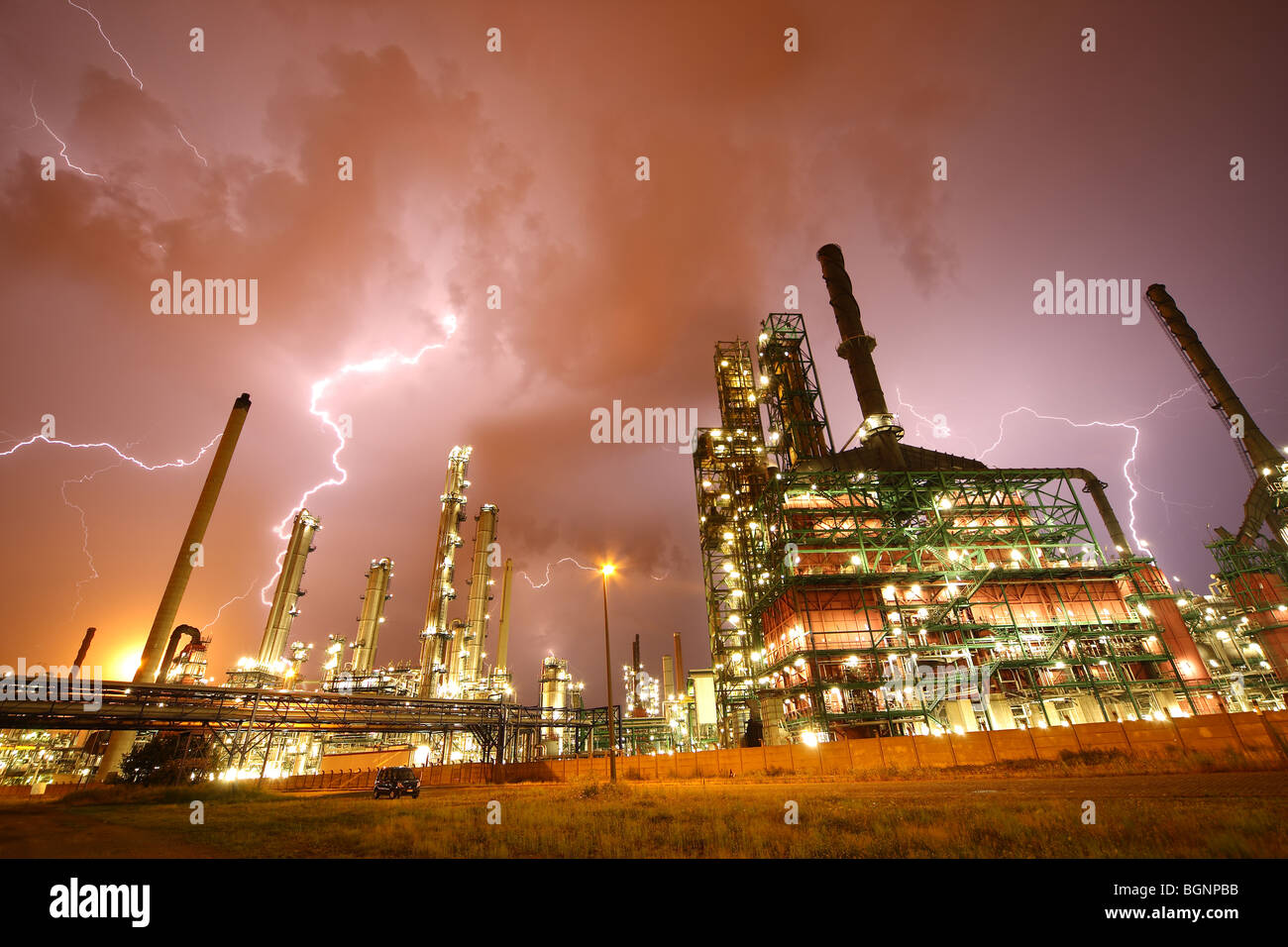 Lightning during thunderstorm above petrochemical industry in the Antwerp harbour at night, Belgium Stock Photo