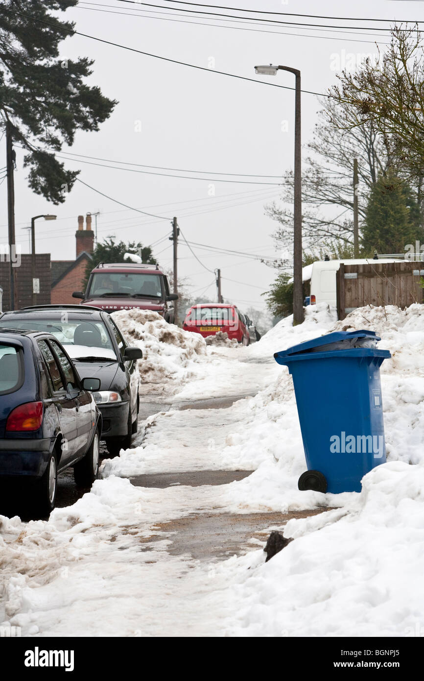 Melting snow on pavement with recyclying wheelie bin Stock Photo Alamy
