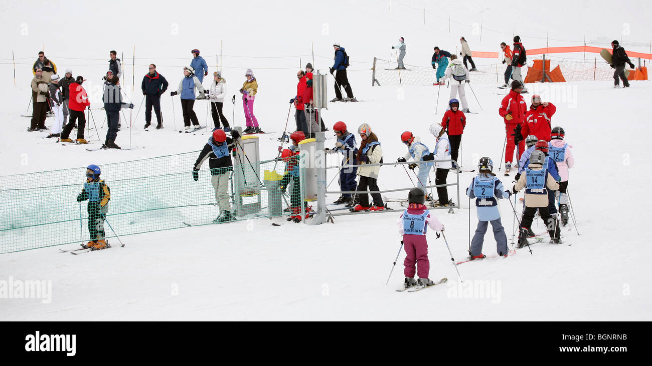 Children learning to ski; Young children in ski school skiing on nursery slopes in Ski School, Avoriaz, Morzine, French Alps, France Stock Photo