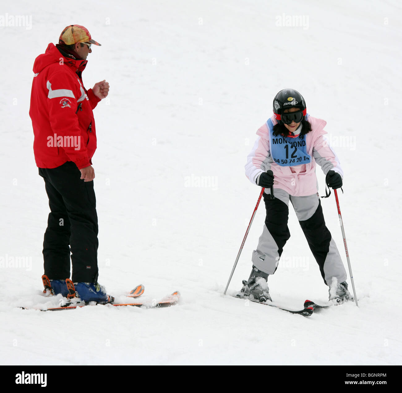 Child learning to ski; A young child having a skiing lesson from a skiing instructor in ski school; Avoriaz, French Alps, France Stock Photo