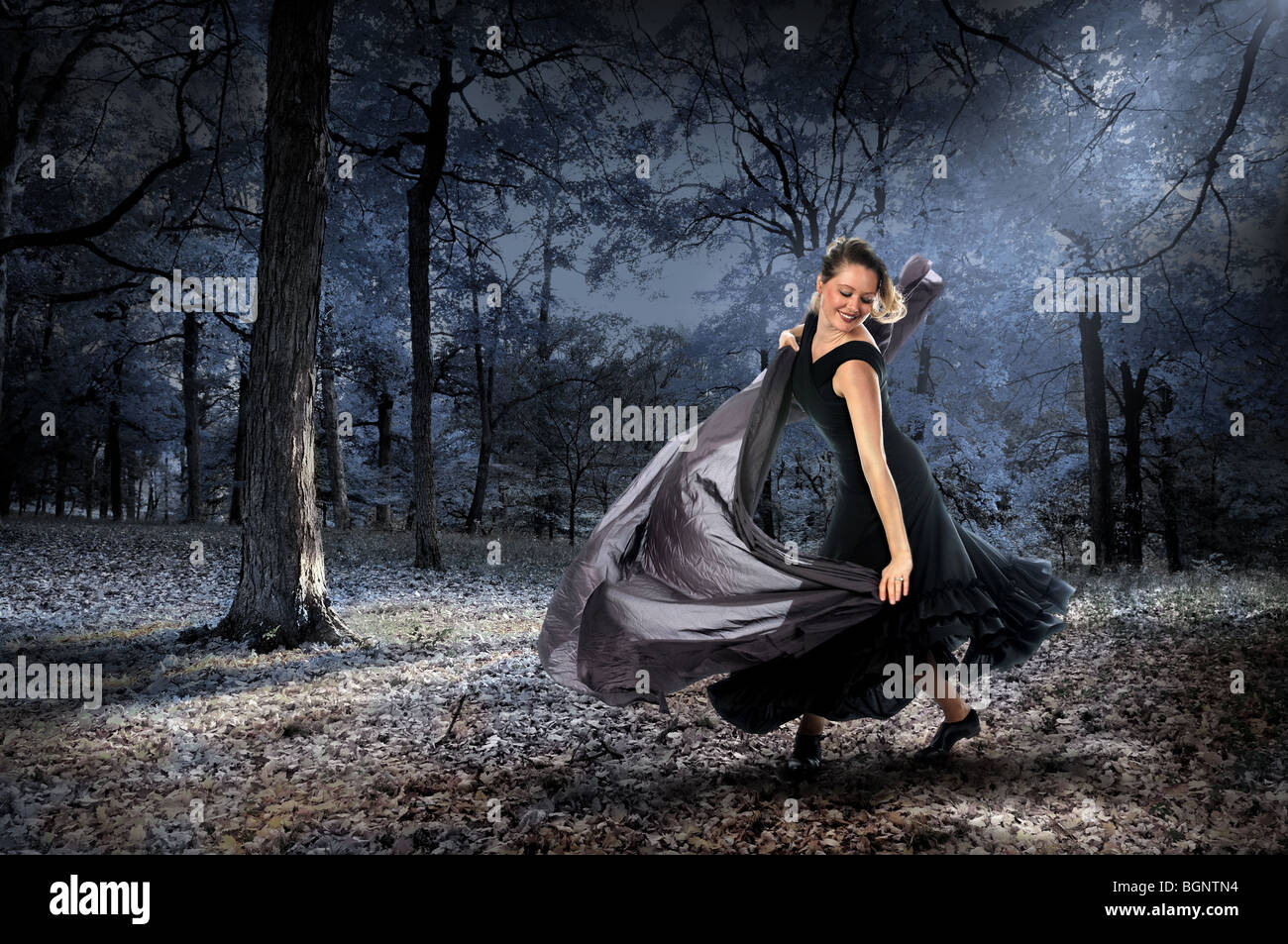 Beautiful woman dancing in the forest during moonlight Stock Photo