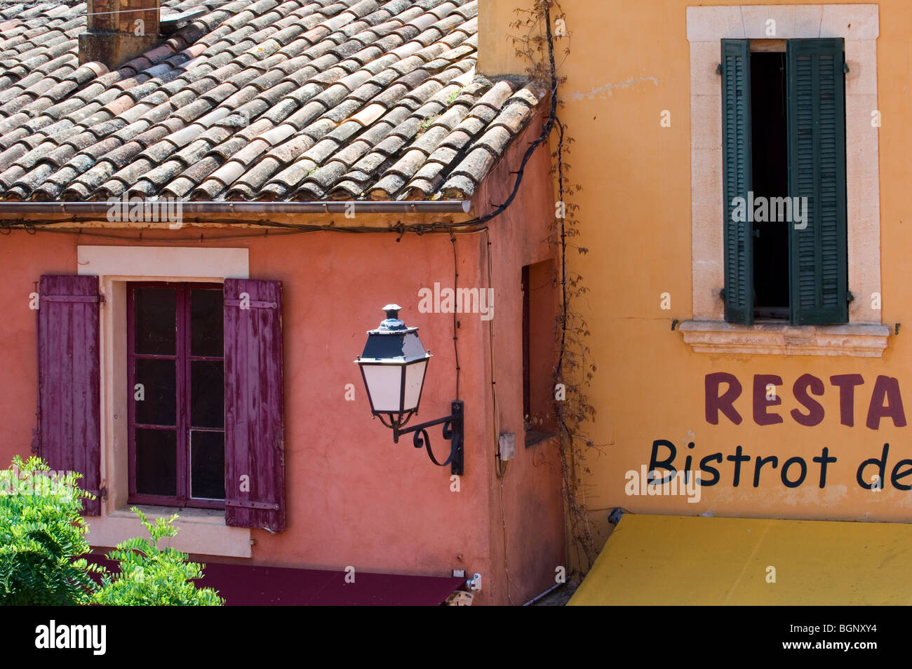 Colourful façades of houses with sunblinds and louvre boards, Roussillon, Provence, Vaucluse, Provence-Alpes-Côte d'Azur, France Stock Photo