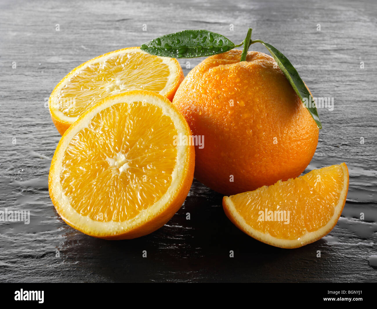 Whole and cut fresh oranges  with leaves Stock Photo