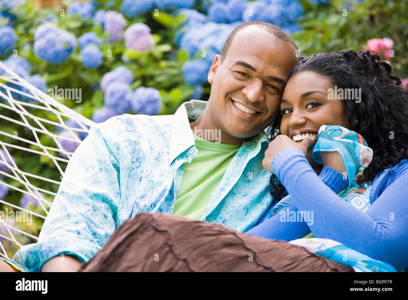 Portrait of a mid adult man and a young woman resting in a hammock ...