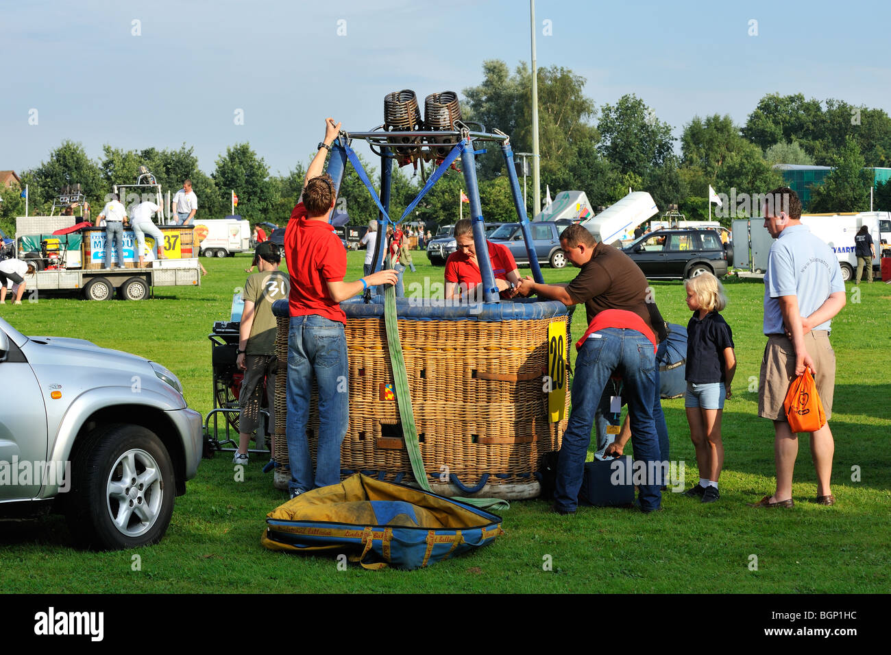 Balloonists / Aeronauts preparing hot-air balloon for taking off during hot air ballooning meeting Stock Photo