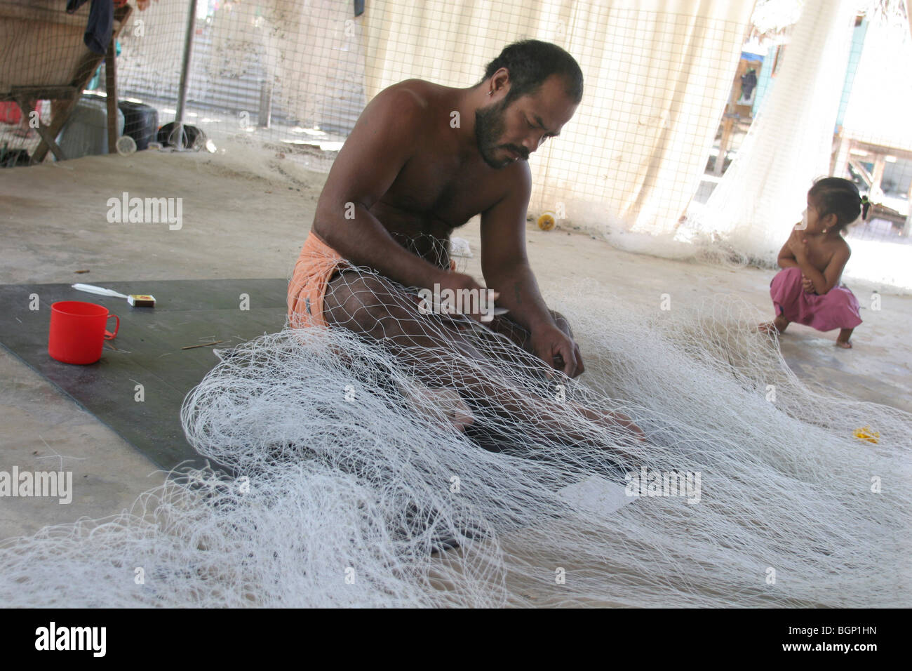 Fisherman mends nets on Kiribati atoll Stock Photo