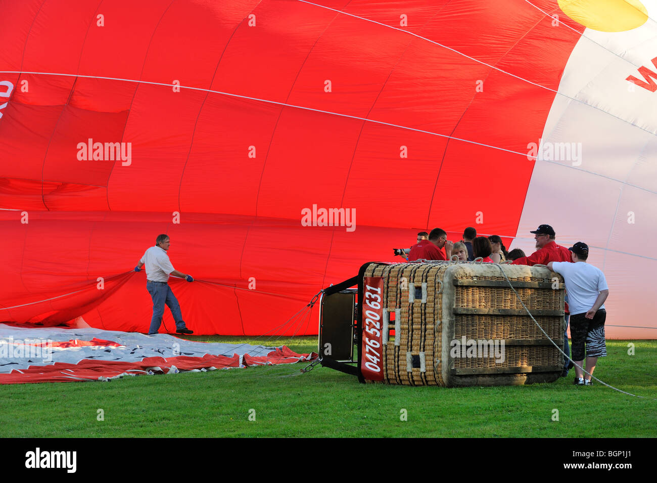 Balloonists / Aeronauts preparing hot-air balloon for taking off during hot air ballooning meeting Stock Photo