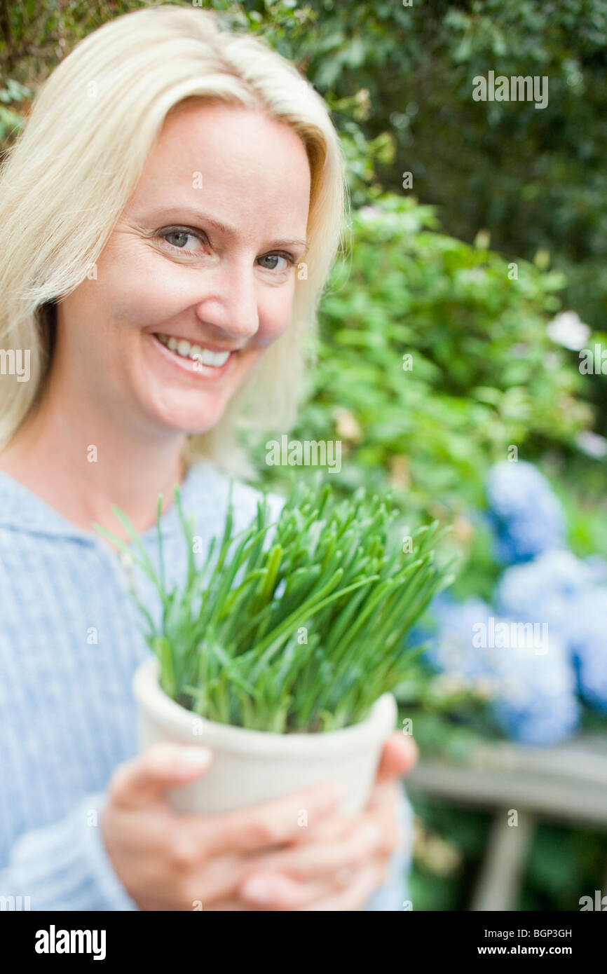 Portrait of a mid adult woman holding a potted plant and smiling Stock ...