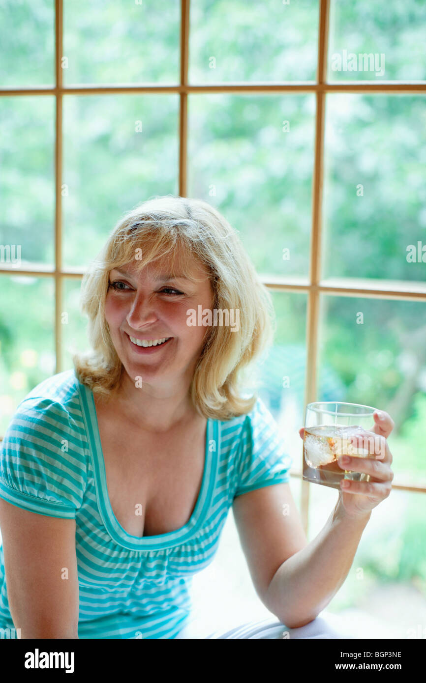 Close-up of a mature woman holding a glass of wine and smiling Stock ...