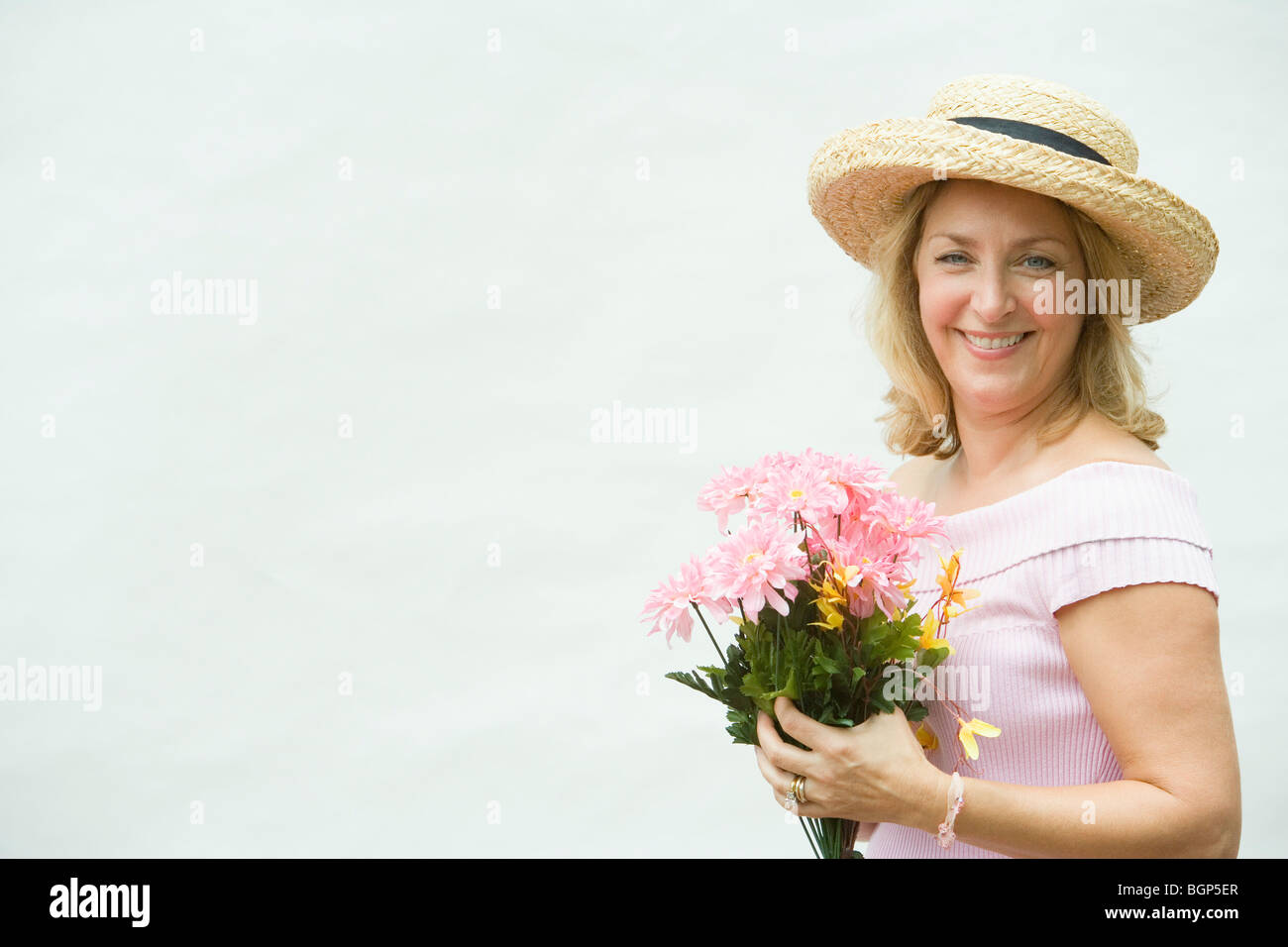 Portrait of a mature woman holding a bouquet of flowers and smiling ...