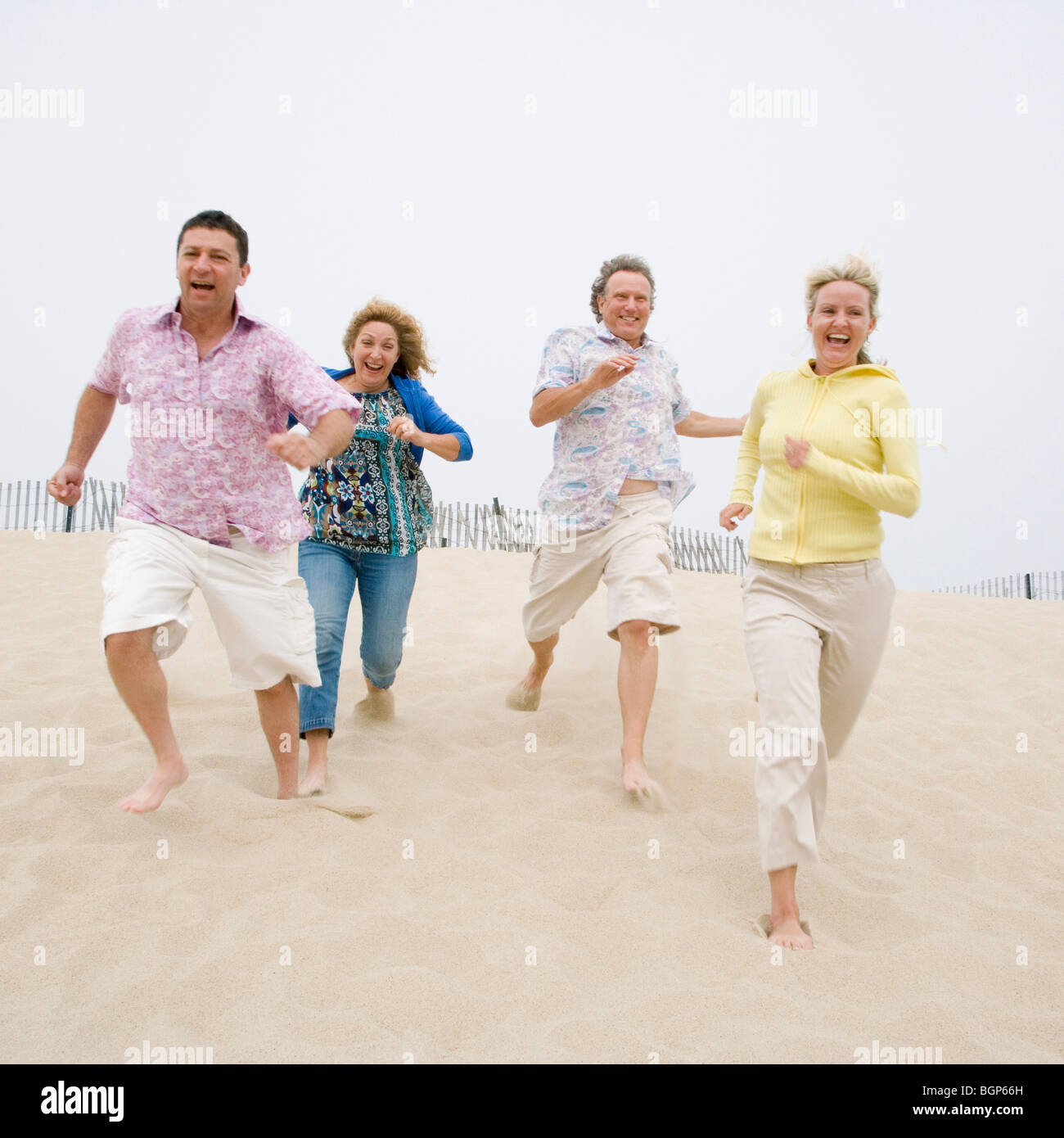 Two couples running on the beach Stock Photo