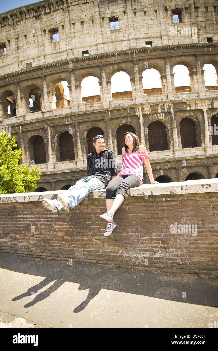 Young couple sitting by the Colosseum Stock Photo