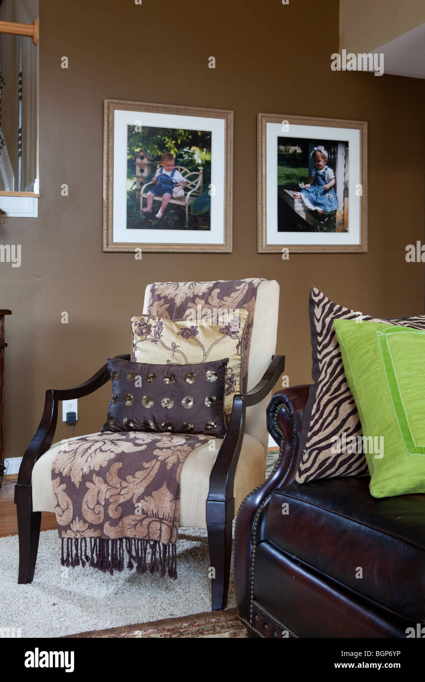 ARMCHAIR IN SITTING ROOM COVERED WITH BLANKET AND MATCHING PILLOWS. AMERICAN COUNTRY HOME Stock Photo