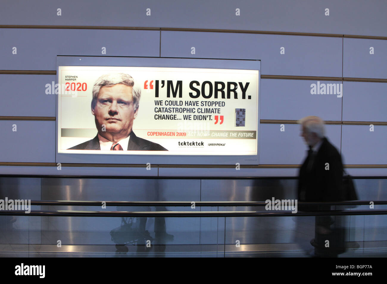 COP 15 in Copenhagen december 2009, adverts at Copenhagen Kastrup airport,  a passenger passing by a greenpeace advert Stock Photo - Alamy