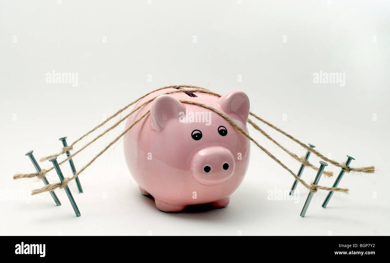 A PIGGY BANK  SECURED WITH ROPE AND NAILS RE SECURE BANKING,BANKS,SAFE,FINANCE SAVINGS THE ECONOMY WAGES MONEY RECESSION CASH UK Stock Photo