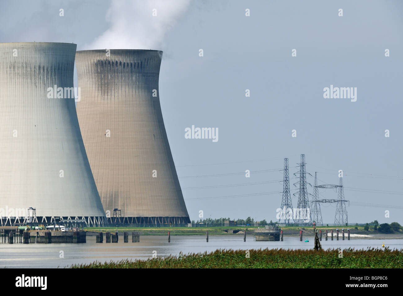 Power lines and the cooling towers of the Doel Nuclear Power Station along the river Scheldt in Antwerp, Belgium Stock Photo