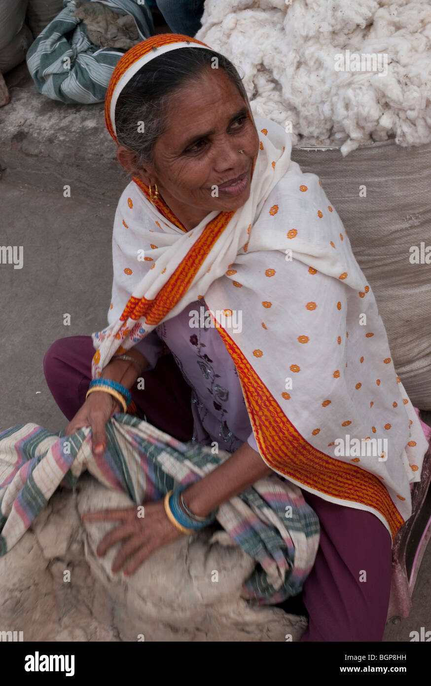 An Indian woman in a saree stuffing cotton wool into a mattress, Delhi, India Stock Photo
