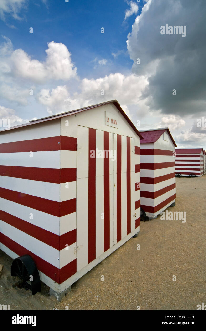 Row Of Colourful Red White Striped Beach Cabins On Wheels Along