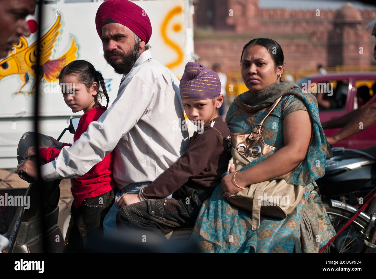 A Sikh family of four riding a scooter, downtown Delhi, India Stock Photo