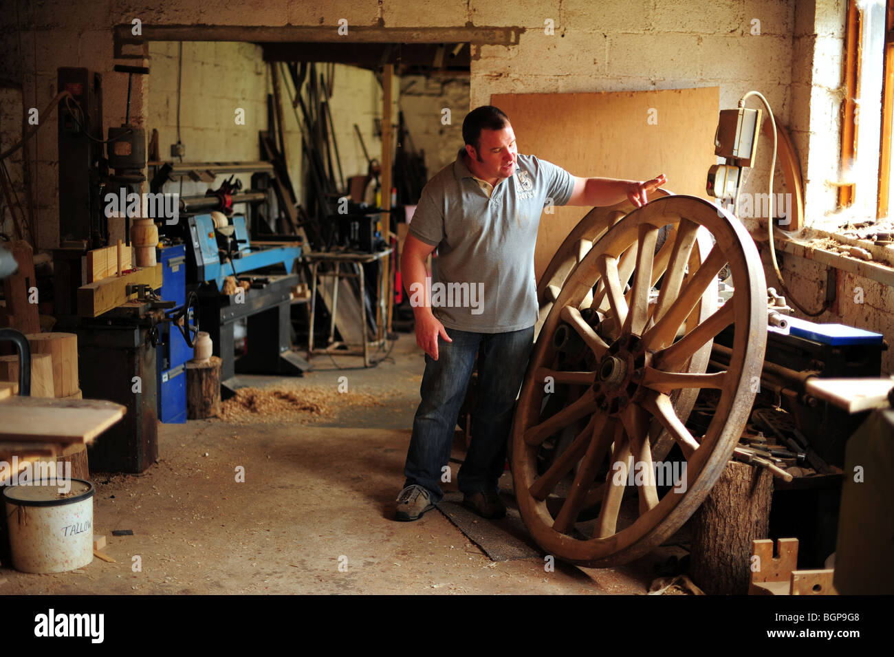 Greg Rowland, a traditional Wheelwright pictured with a wooden carriage wheel in his workshop in Colyton, Devon. Stock Photo