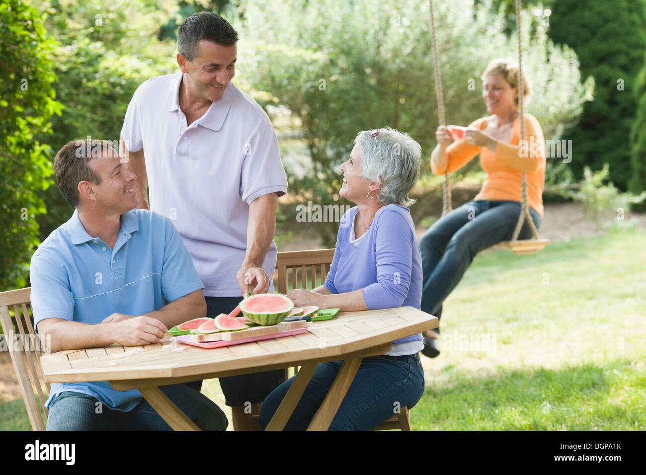 Two mature couples in a lawn Stock Photo