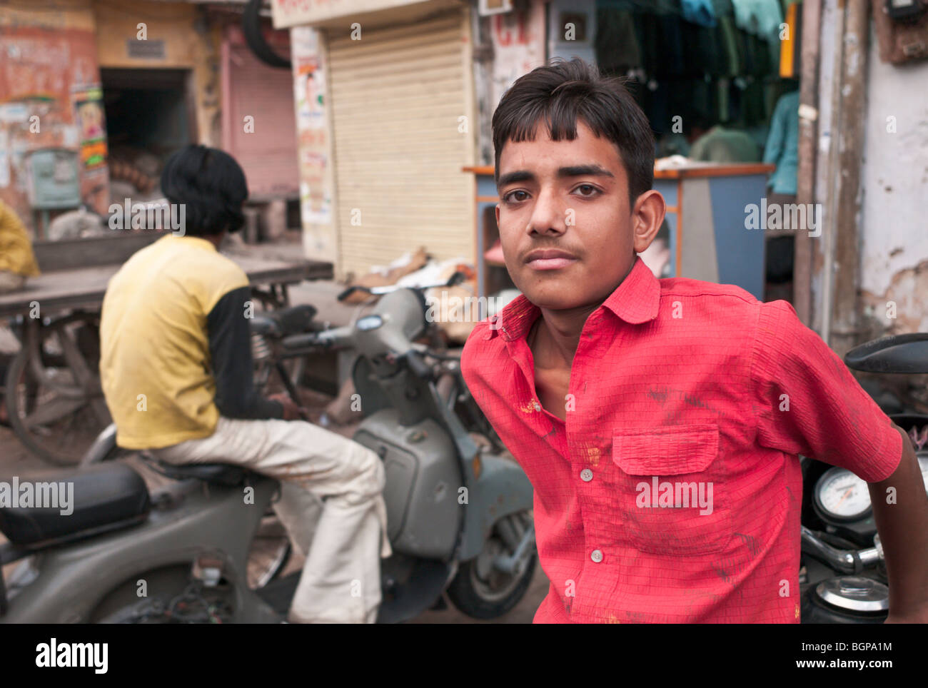 Young Indian boys sitting on scooters in a backstreet in Jaipur, India Stock Photo