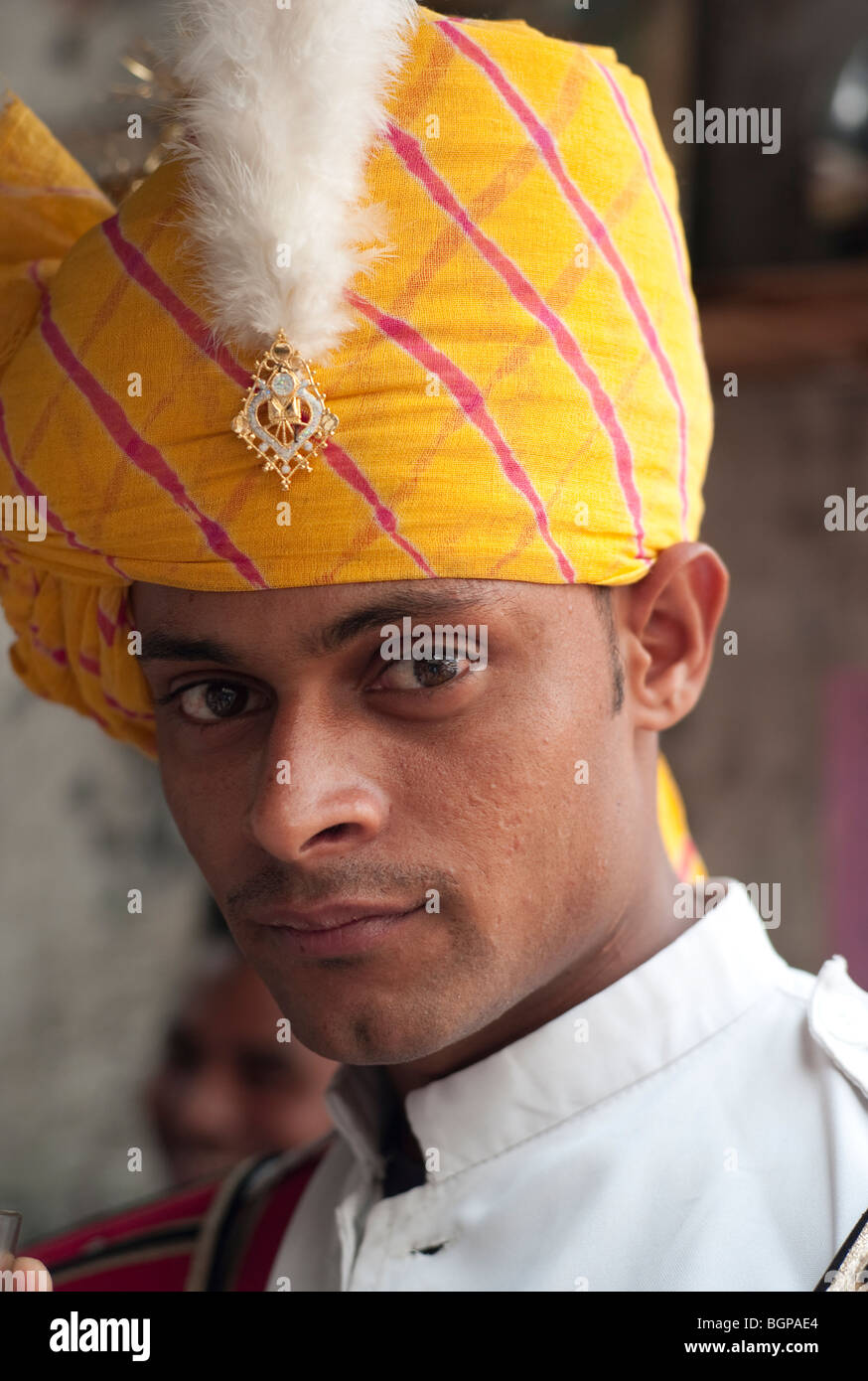 Portrait of an Indian male band member in yellow head dress with white feather Stock Photo
