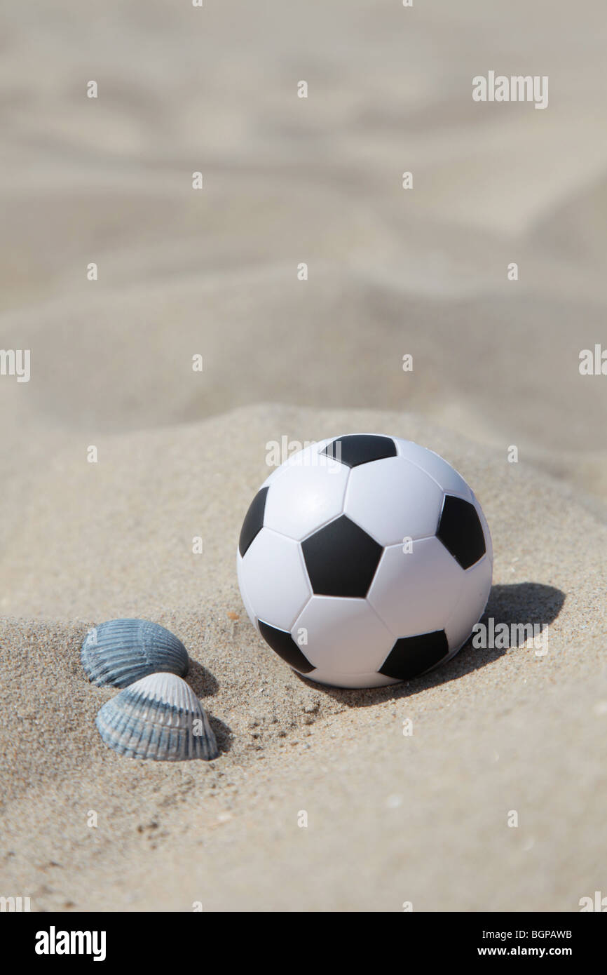 A soccer ball lying in the sand on the beach Stock Photo Alamy