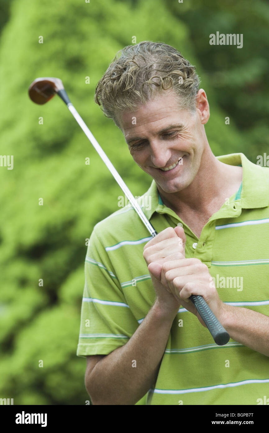 Close-up of a mature man holding a golf club and smiling Stock Photo