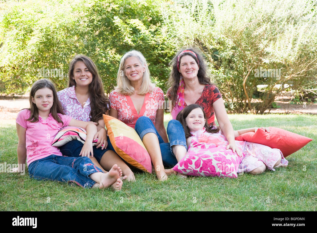 Portrait of two families sitting on grass Stock Photo