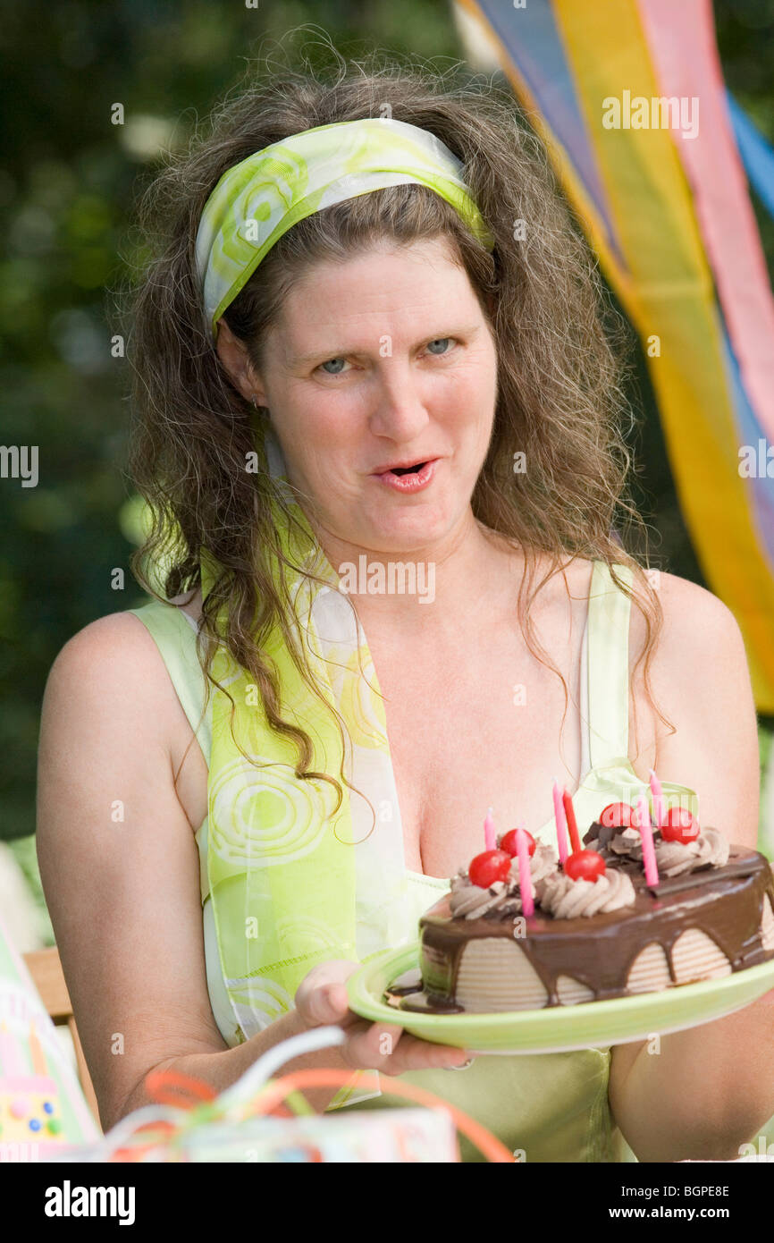 Portrait of a mature woman holding a birthday cake Stock Photo - Alamy