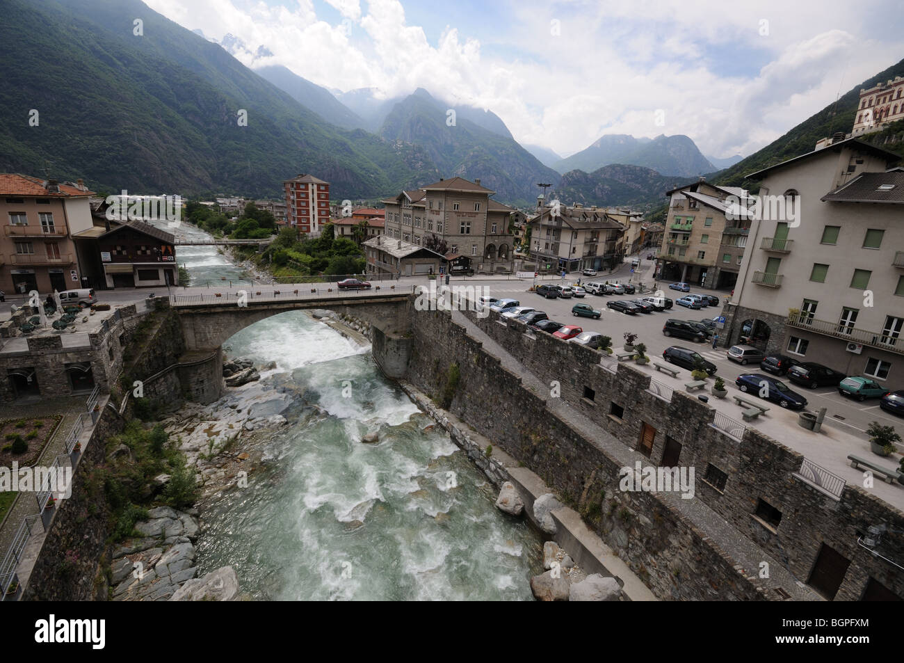 View from Roman Bridge down River Torrente Lys Pont St Martin Aosta Valley Italy part of town and mountains behind Stock Photo