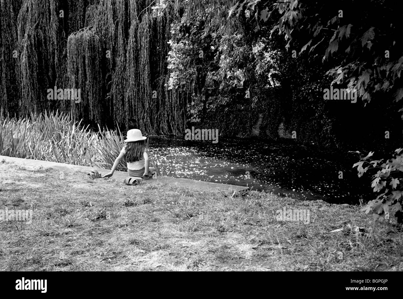 Baby girl alone at the edge of a river South London Stock Photo