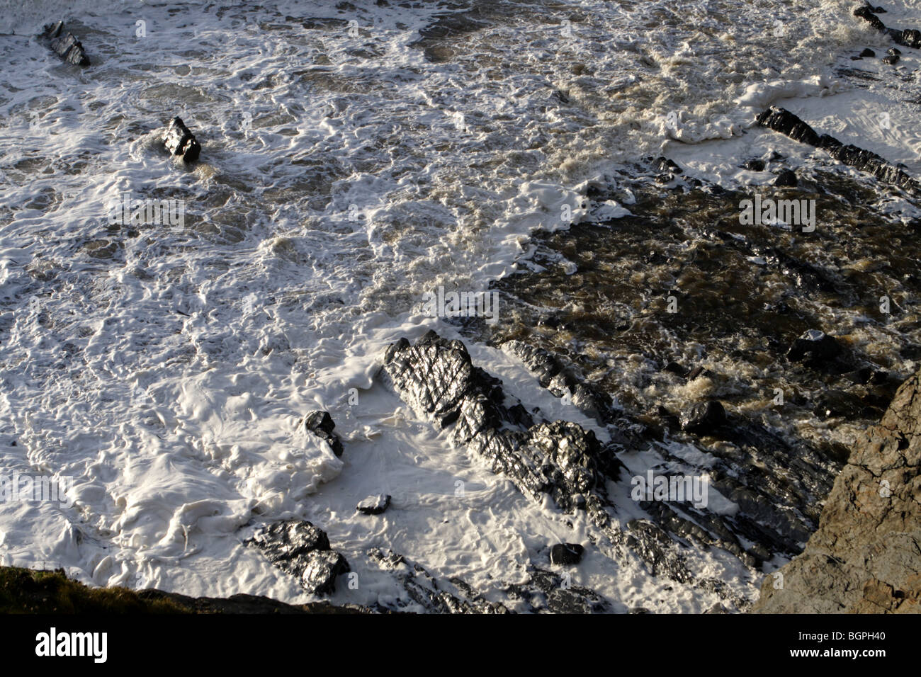 Waves break onto the rocks at Welcombe Mouth on the devon cornwall border Stock Photo