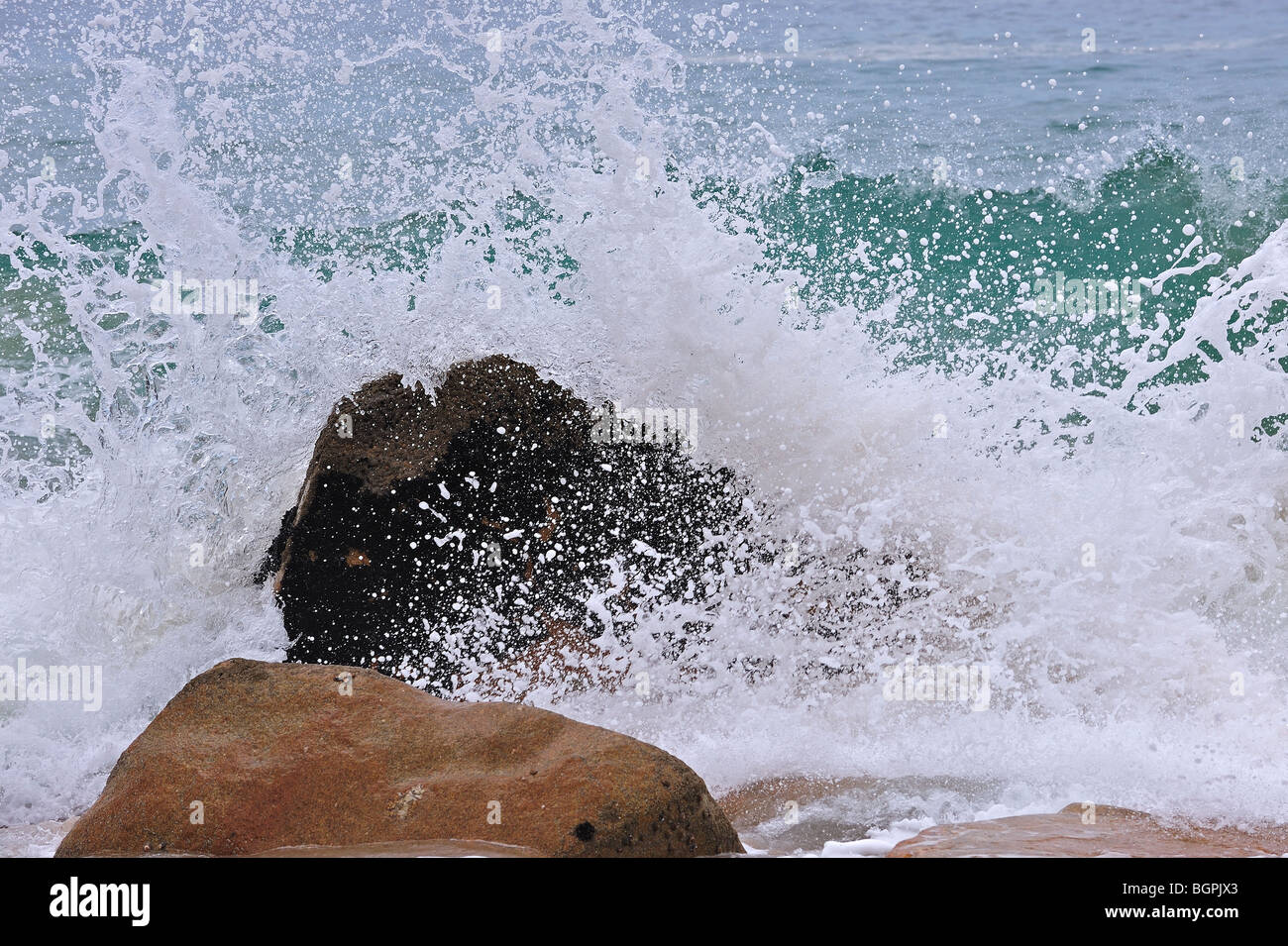 Wave crashing into boulder in the surf at the Côte Sauvage / Wild Coast, Quiberon, Brittany, France Stock Photo