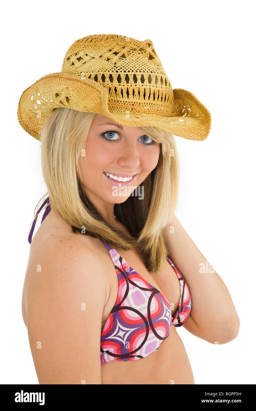 Beautiful Caucasian teenager standing on white background in a bikini with a cowboy hat smiling with some attitude Stock Photo