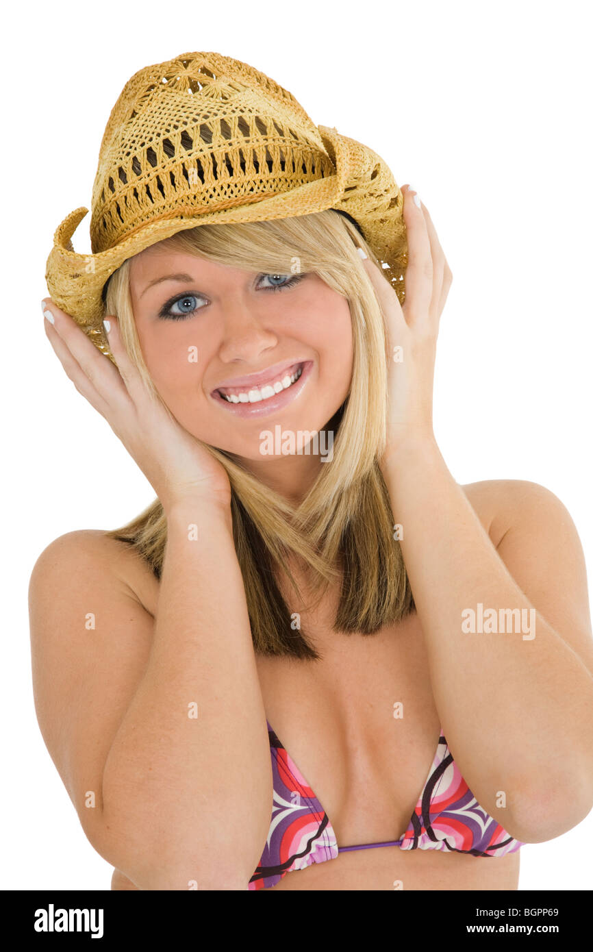 Beautiful Caucasian teenager standing on white background in a bikini with a cowboy hat smiling with some attitude Stock Photo