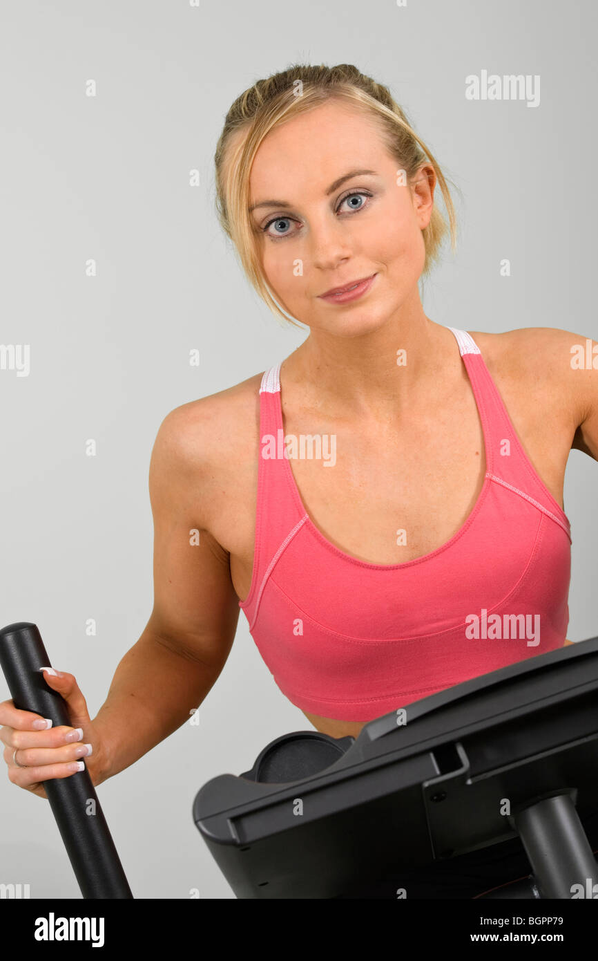 Caucasian woman in early 20s exercising on a cardiovascular machine Stock Photo