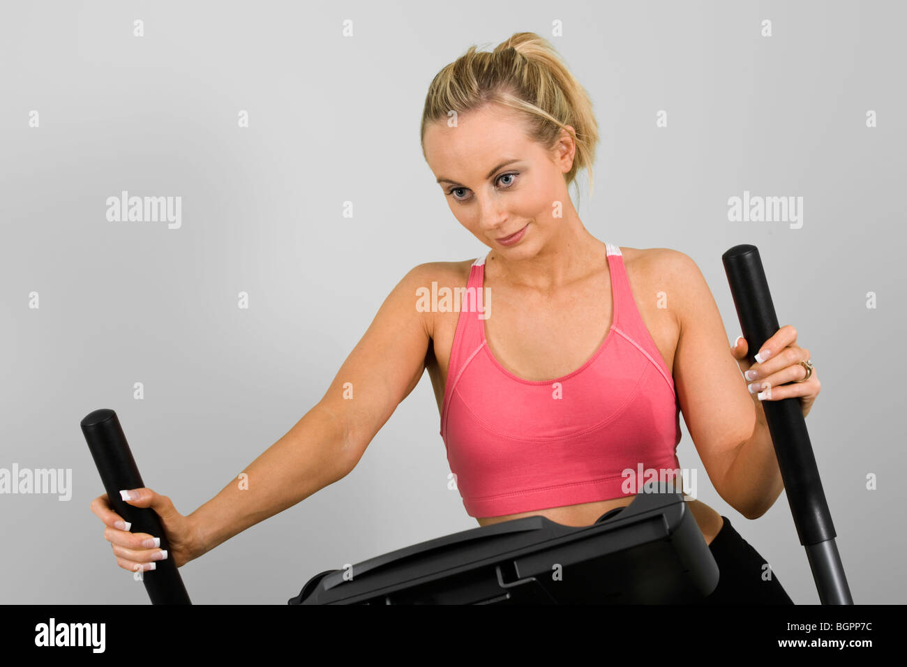 Caucasian woman in early 20s exercising on a cardiovascular machine Stock Photo
