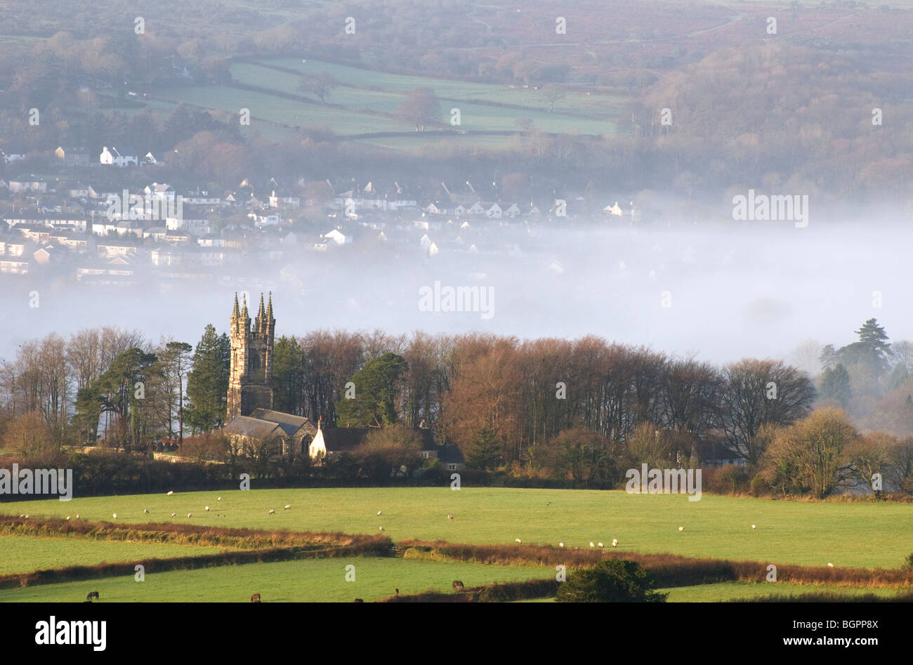 Walkhampton Church with a misty valley and houses at Horrabridge behind