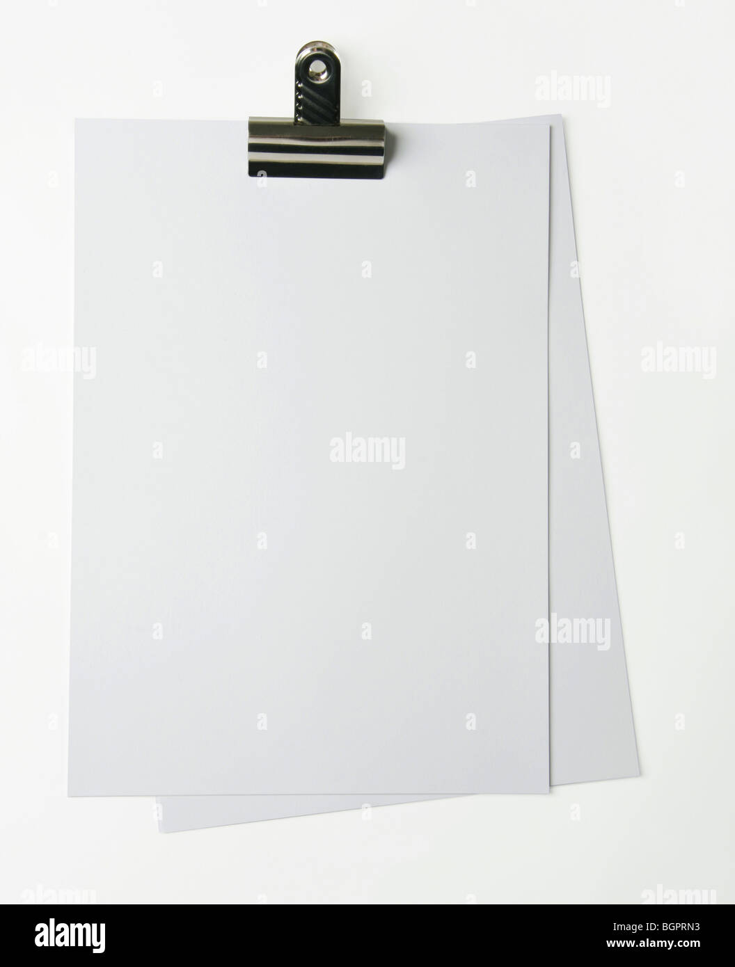 White blank paper sheets held with a bulldog clip. Perfect for notes or adding text too. Stock Photo
