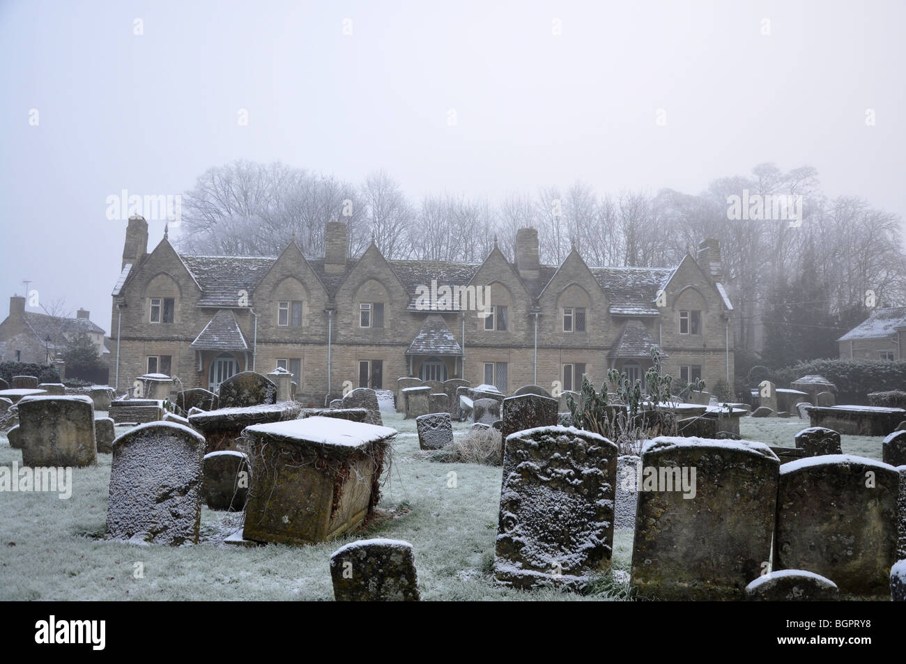 Graves and head stones next to row of old houses in Witney in winter Stock Photo